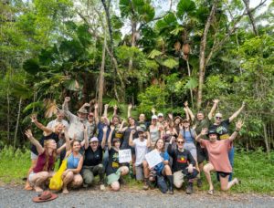 Group of people on the edge of the Lot 110 of the Daintree Rainforest holding a 'Saved! Thank you' sign,